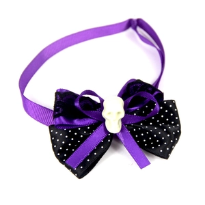 Close-up of Halloween purple bow tie with skull charm and black lace for pets