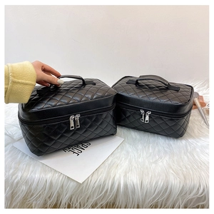 Detailed view of black PU leather travel toiletry bags with elegant quilted stitch patterns