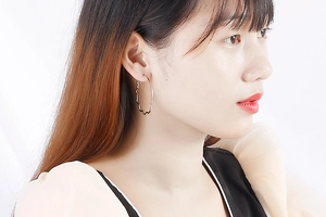 Close-up of wavy silver hoop earrings on a model showing modern minimalist style