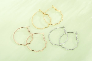 Detailed top view of large wavy metallic hoop earrings in gold, silver, and rose gold