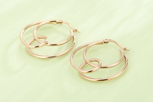 Polished rose gold triple-interlocked hoop earrings with glossy metallic texture