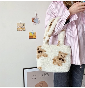 Close-up of soft white sherpa fleece tote bag featuring a cute brown bear pattern