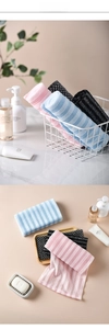 Detailed view of striped long exfoliating back scrubber towels in pink, blue, and charcoal