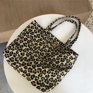 Top view of leopard print canvas tote bag on a round white table with textured fabric detail