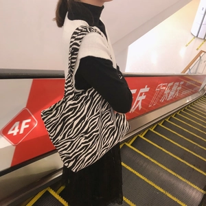 Close-up of zebra print canvas tote bag with black and white animal pattern on shoulder
