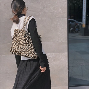 Street style shot of a woman carrying a minimalist leopard print canvas tote bag on her shoulder
