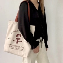 Détail du sac cabas en toile avec imprimé de caractères chinois traditionnels et bandoulière