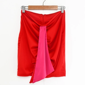 Dettaglio di minigonna rossa e fucsia con design drappeggiato sul davanti
