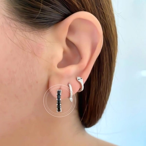 Close-up of minimalist silver hoop earring with rectangular black zircon stone inlay