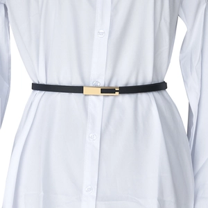 Detail of slim black leather belt with gold rectangular buckle on a white shirt