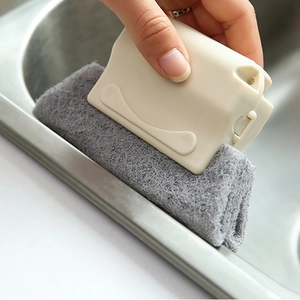 Window groove cleaning brush with beige handle and grey fiber sponge shown in use on sink