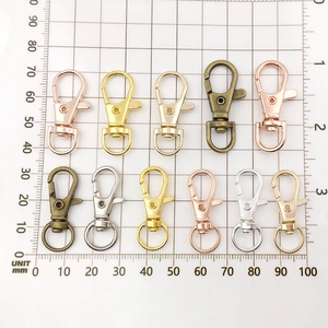 Zinc alloy lobster clasps in multiple finishes displayed on a metric measuring grid