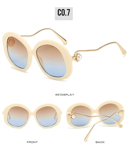 Detail view of oval sunglasses with gradient lenses and pearl decorated metal temples