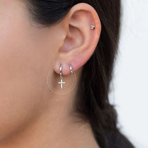 S925 Sterling silver hoop earrings set with zircon cross pendant on a model's ear