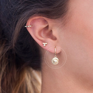 Golden Evil Eye hoop earrings with white zircon on a model for a chic bohemian style