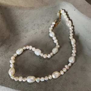 Elegant 925 sterling silver baroque pearl necklace with gold clasp on a gray stone tray