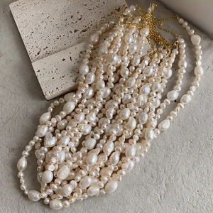 Artistic baroque pearl necklace with irregular cream pearls and gold-plated chain links