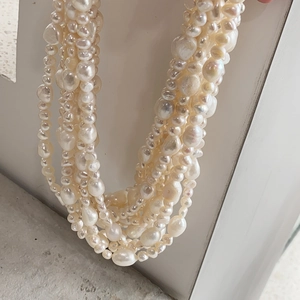 Detailed view of layered baroque pearls with natural luster and woven textures