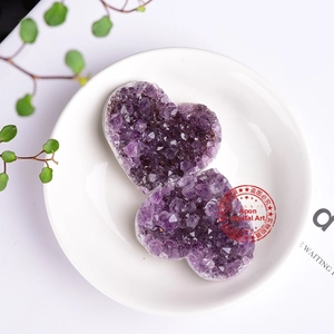 Detailed top view of natural heart shaped purple amethyst clusters in a white bowl