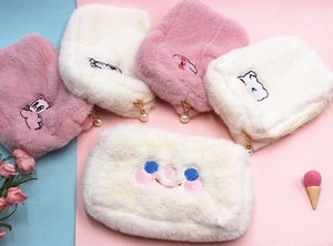 Détail de trousses à maquillage en peluche avec broderie et tirette en perle