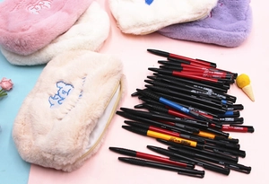 Détail de trousses en peluche avec broderie chien bleu et ensemble de stylos de bureau