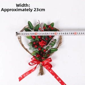 Detailed view of 23cm heart-shaped Christmas wreath with red berries and stars