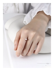 Minimalist S925 silver ring featuring a round white pearl and zircon on model finger