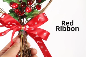 Close-up of Christmas wreath featuring red berries, green leaves and a red satin ribbon