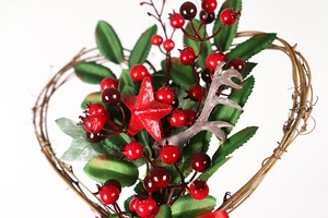 Close-up of heart-shaped twig wreath with red berries, star and pine needle details