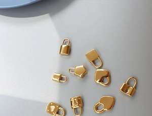 Detailed view of assorted gold titanium steel mini lock charms in various shapes