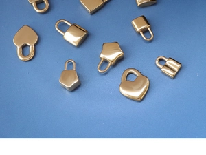 Macro shot of gold heart star and lock pendants on a textured blue surface