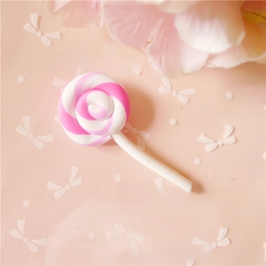 Gros plan de sucette spirale rose et blanche en pâte polymère pour loisirs créatifs