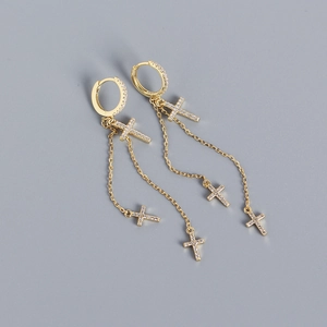 Close-up of golden S925 silver cross earrings with shimmering tassel charms and tiny diamonds