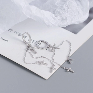 Detail of S925 sterling silver cross earrings with dangling tassels and sparkling crystals