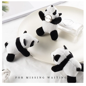 Three cute plush panda brooches set on a white decorative plate with home decor