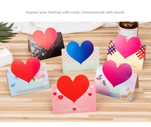 Detail of 3D heart folding greeting cards with floral and polka dot patterns on wood