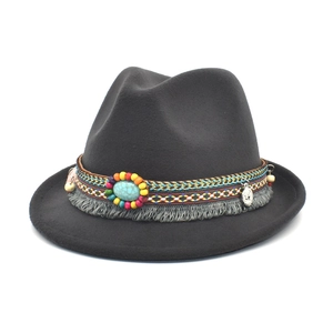 Detailed view of dark grey felt fedora featuring bohemian beaded band with tassels