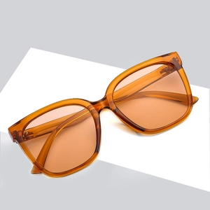 Occhiali da sole quadrati ambrati con lenti color arancio per un look elegante