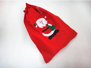Dettaglio del sacchetto regalo di Natale rosso con motivo Babbo Natale e cordoncino