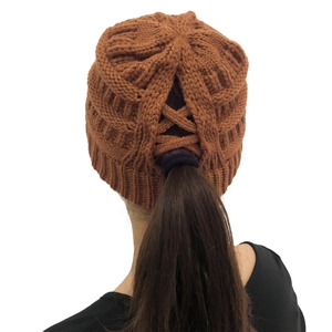 Close-up of caramel knitted beanie showing the unique ponytail hole design for women