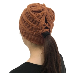 Detail view of the ponytail opening on this warm caramel brown knitted winter hat