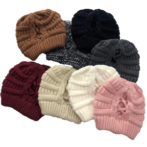 Folded winter knit beanies in various colors featuring a cross-knit pattern and soft texture