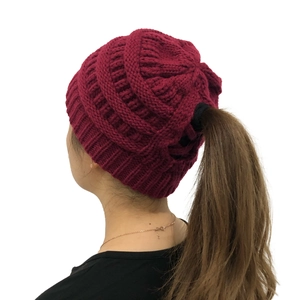 Detailed view of wine red cable knit beanie featuring a convenient ponytail opening