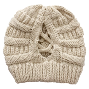 Detail of cream knit beanie featuring a cross-back ponytail hole design on white background