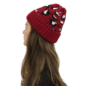 Detail view of the thick ribbed cuff and red leopard pattern on knit beanie