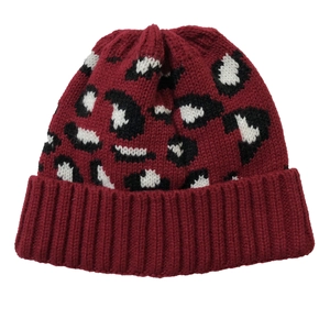Detail of burgundy leopard print knitted beanie showing textured fabric and cuffed edge