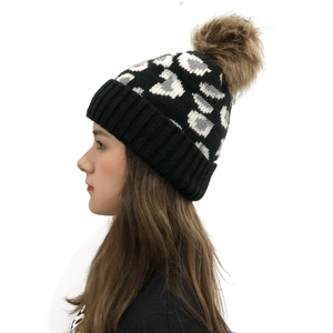 Women's leopard print knit beanie with a large faux fur pompom and fold-over cuff