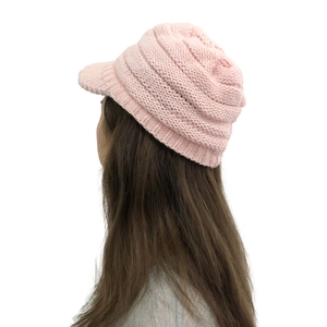 Side view of pink knitted visor beanie showing textured knit and ear protection fit