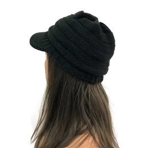 Detail of black winter knitted visor beanie showing ear protection and thick wool texture