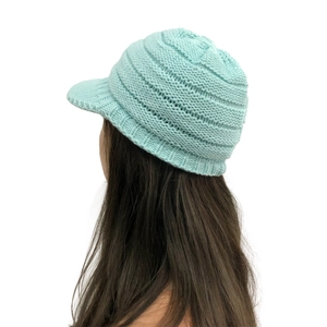 Detail view of winter knitted visor beanie in light blue showing warm cable knit texture